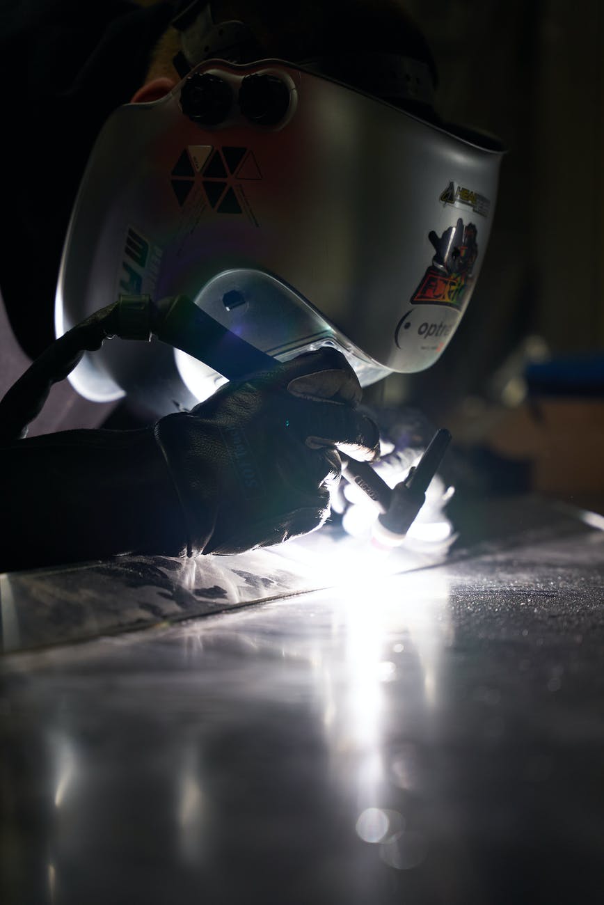 a person wearing a protective head shield welding metals